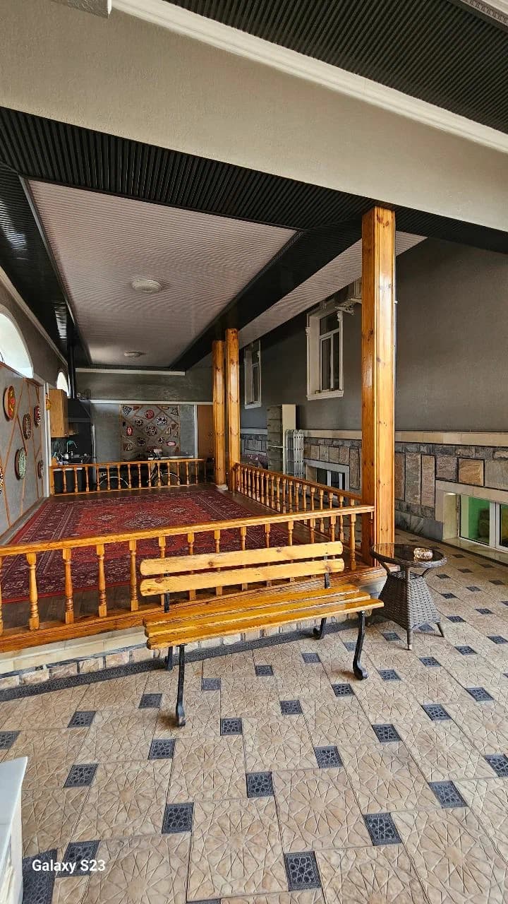 Айван Villa Anor: деревянная супа с красным ковром, резные колонны и скамья