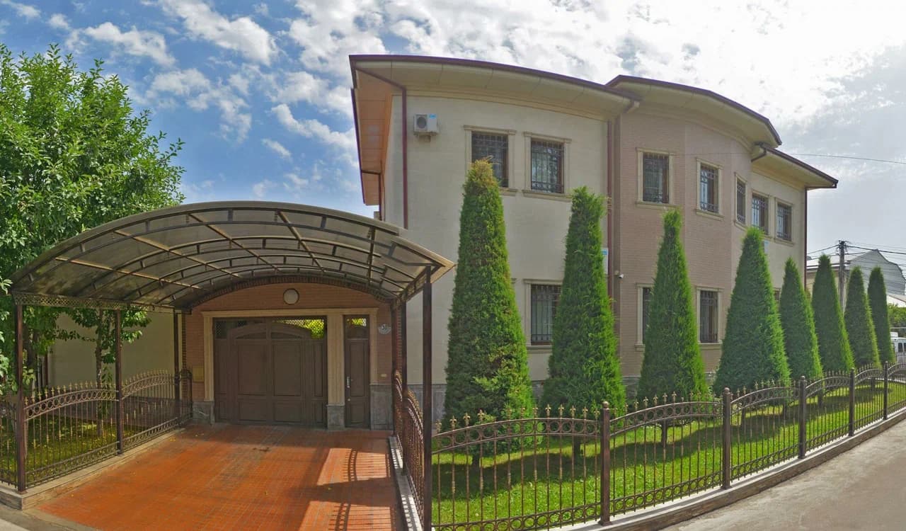 Фасад Villa Anor со стороны улицы Чамбил, навес для машины и туи